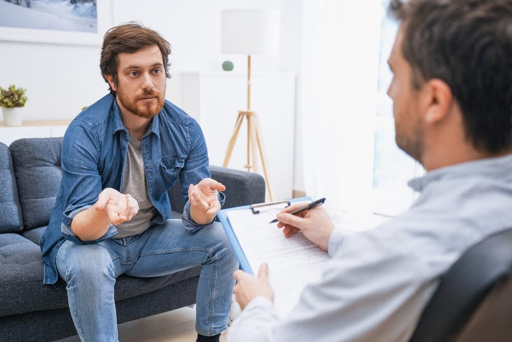 An image representing a mental health clinician guiding a client through therapeutic techniques to address PTSD symptoms