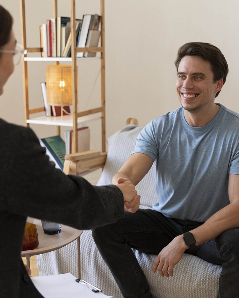 Patient and therapist shaking hands during an individual therapy session, discussing Aetna behavioral health coverage options